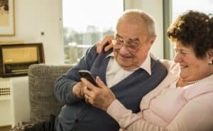 Senior couple using smartphone at home